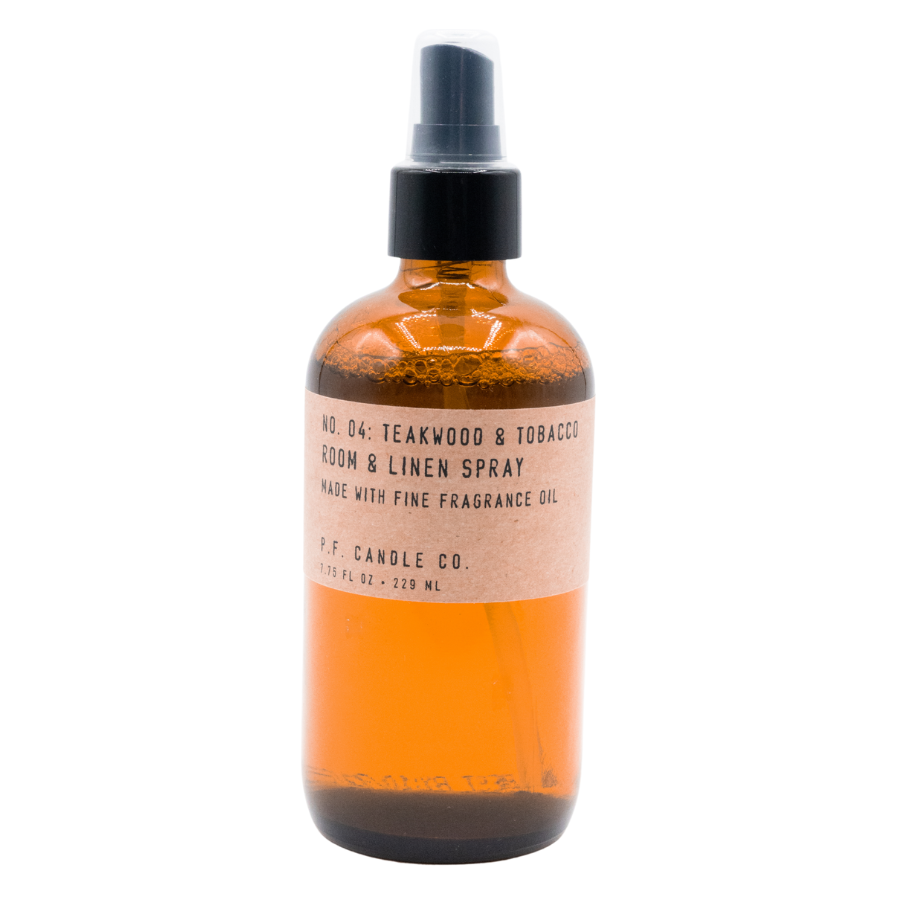 Amber bottle of teakwood and tobacco room and linen spray with label and black spray cap