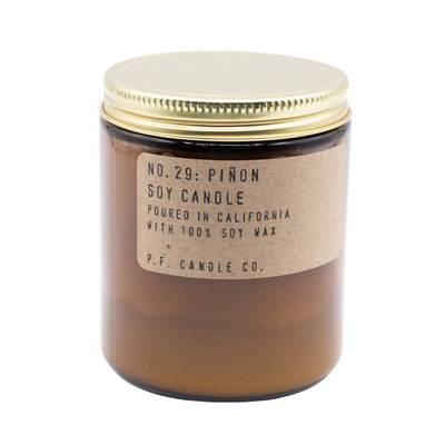 Amber glass jar with gold lid, labeled No. 29 Piñon soy candle, minimalist design