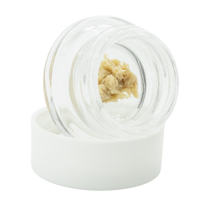 THCa rosin concentrate in a clear glass jar on a white background